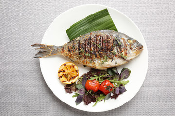 Plate with delicious fried fish on table