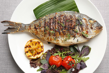 Plate with delicious fried fish on table