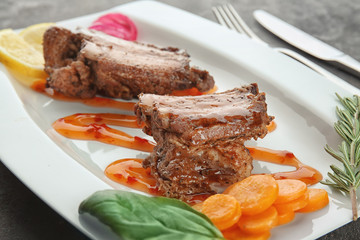 Plate with delicious ribs and vegetables, closeup
