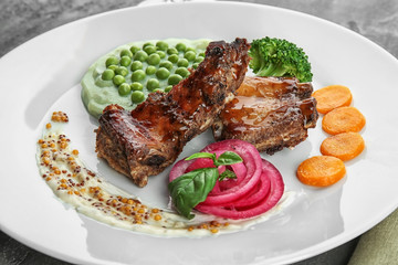 Plate with delicious ribs, vegetables and mushy peas, closeup