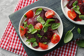 Plate with fresh beet salad on wooden board