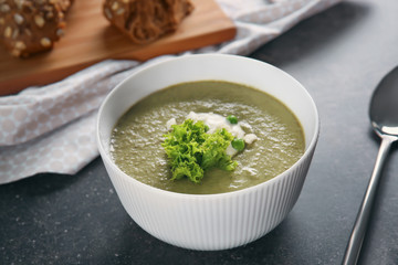 Bowl with fresh kale soup on table