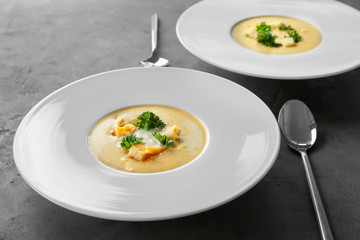 Plates with broccoli cheddar soup on table