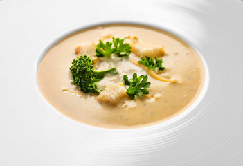 Plate with broccoli cheddar soup, close up