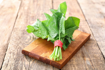 Fresh spinach bunch on wooden board