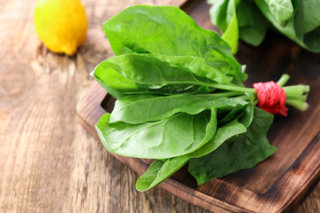 Fresh spinach bunch on wooden board