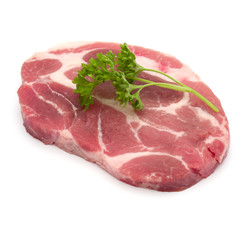 Raw pork neck chop meat with parsley herb leaves garnish isolated on white background cutout