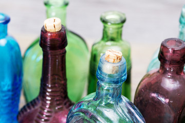 Coloured glass bottles on a rustic background