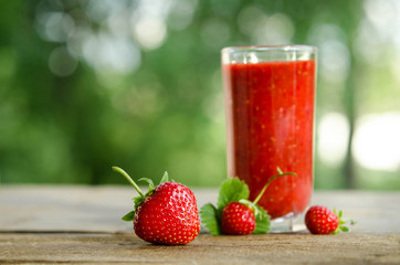  strawberries and strawberry cocktail smoothie on a wooden table