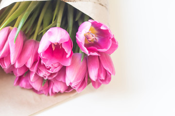 close up picture of fresh pink and purple tulips on table 