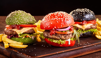 Three colorful Asian burgers with French Fries