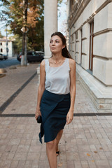 Fototapeta premium Beautiful brunette young woman walking through the streets of Old City. Fashion concept