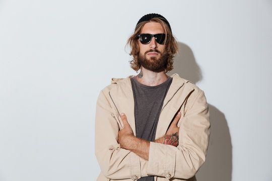 Bearded hipster man wearing sunglasses standing isolated
