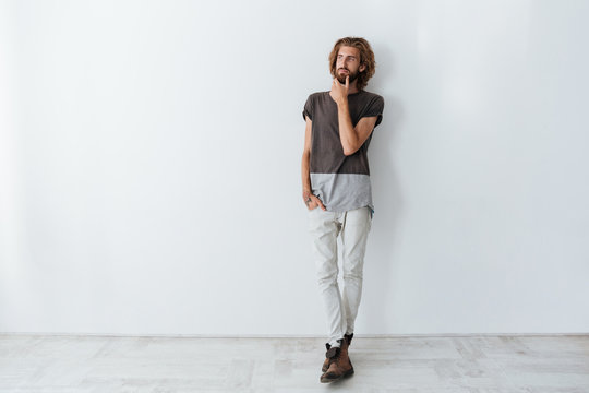 Caucasian handsome man standing isolated over grey wall