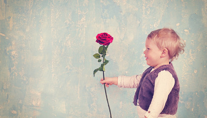 kleiner Junge mit roter Rose