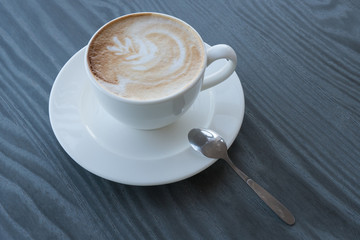 A cup of cappuccino on a dark table