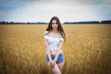 Beautiful woman girl looking at camera. close-up to very beautiful girl with amazing green eyes red lips and attractive face. cute amazing portrait in the field of wheat. birthmark on the face