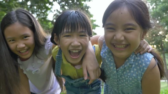 4K : Group of little happy Asian girls playing together in the park