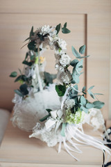 White basket decorated with ribbons and pastel greenery