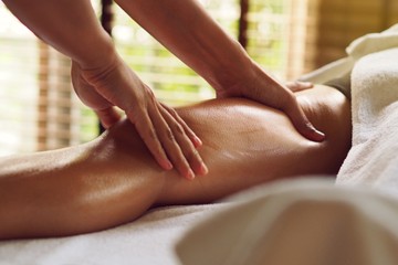 Therapist doing massage foot massage in spa treatment room.