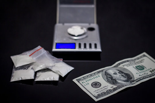 scales and many cocaine on black table