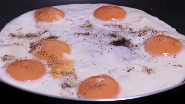 Fried eggs in pan with peppers