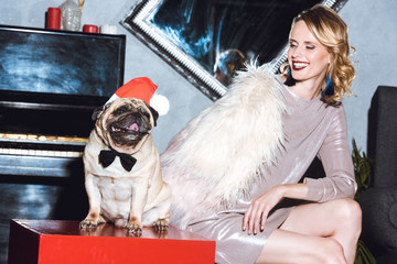 woman with pug in santa hat