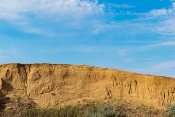 Epic view of the steep rock and the bright sky with clouds