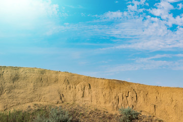 Epic view of the steep rock and the bright sky with clouds. Bright sunny light
