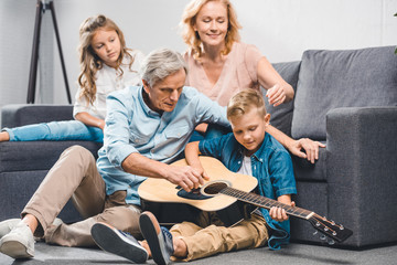 family playing on guitar