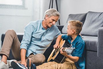 grandfather and grandson playing on guitar