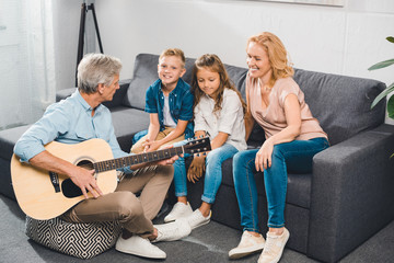 family playing on guitar
