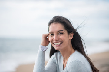 Portrait of a beautiful young brunette woman on the beach