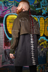 Obraz premium A creative, unusual red-haired man in designer clothes and tunnels in his ears, posing in the studio.