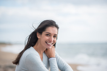 Portrait of a beautiful young brunette woman on the beach