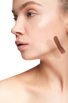 Gorgeous beautiful woman with stripes of different type of cream on face. Studio photo. Beauty and skin care