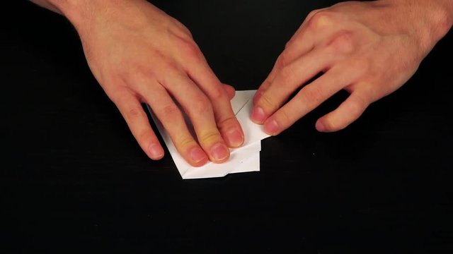 A man folds a white origami dog - closeup from above - timelapse