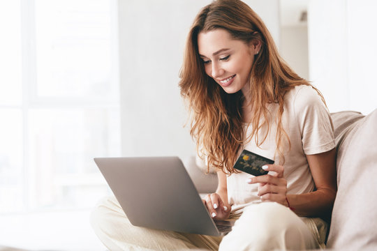 Young Woman Working With Laptop And Credit Card At Home