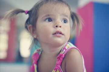 Fototapeta na wymiar Little Caucasian baby in playground. Cute little girl looking away.