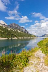 Fototapeta na wymiar Fedaia Lake in Dolomites Alps, Italy