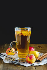 Cup of tea with apple and spices on wooden background Vertical Toned