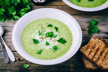 bowl of green zucchini cream soup with fresh parsley