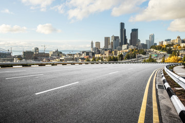 empty road with cityscape of modern city in blue sky © zhu difeng