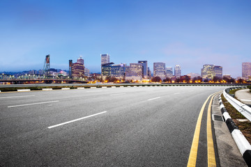 empty road with cityscape of modern city in blue sky