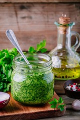 Traditional green chimichurri sauce with fresh parsley, red onion, garlic, olive oil in glass