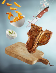 Falling T-bone steak meal with cutting board