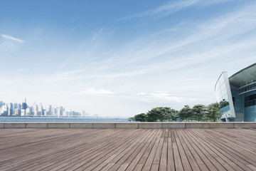 empty wooden floor with cityscape of modern city