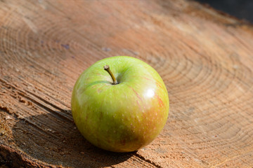 Healthy apple, green and red on wood in the sun