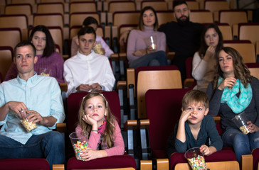 Enthusiastic audience eating popcorn and enjoy watching movie