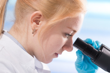 Doctor woman working  a microscope. Female scientist looking through a microscope in lab. Student girl looking in a microscope, science laboratory concept